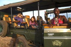 cottars-safaris-family-safari-enock-with-children-in-vehicle-at-door-scaled